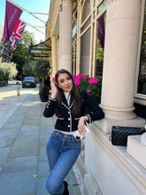 A lady wears a black jacket in Paris in winter.